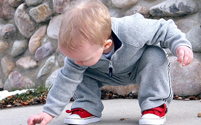 Child Picking up Goose Droppings